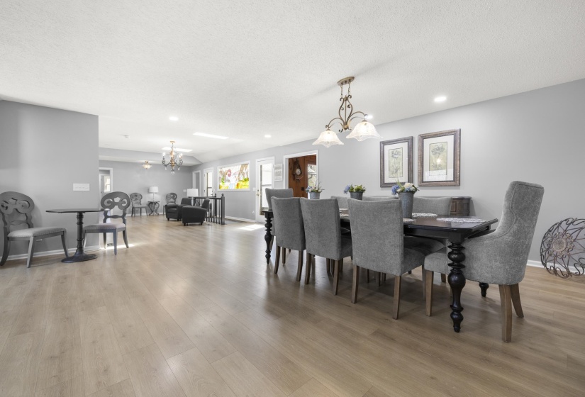 Dining area with suspended lighting, light wood-style flooring, and a textured ceiling