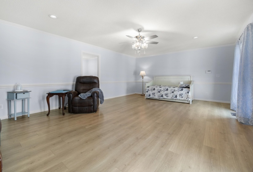 Bedroom featuring light wood finished floors, a ceiling fan, ornamental molding, and recessed lighting