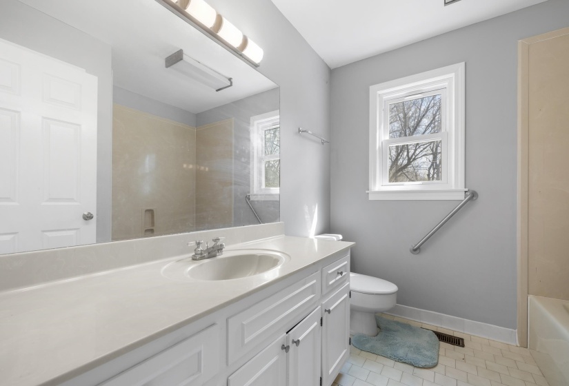 Bathroom featuring vanity, a shower, light tile patterned flooring, and a tub to relax in
