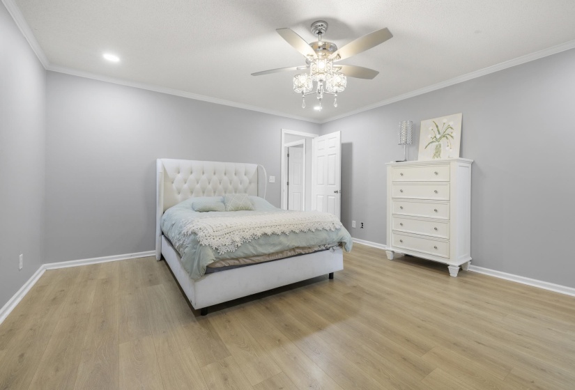 Bedroom featuring crown molding, light wood finished floors, and a ceiling fan