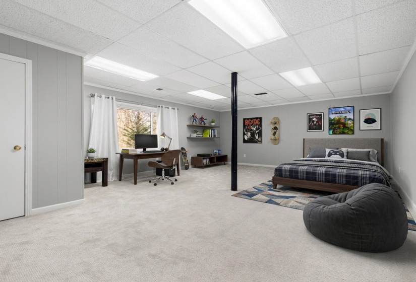 Bedroom featuring an office area, a drop ceiling, and light colored carpet
