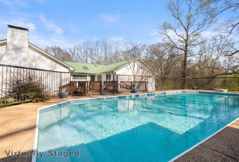 View of pool with a diving board and patio surround