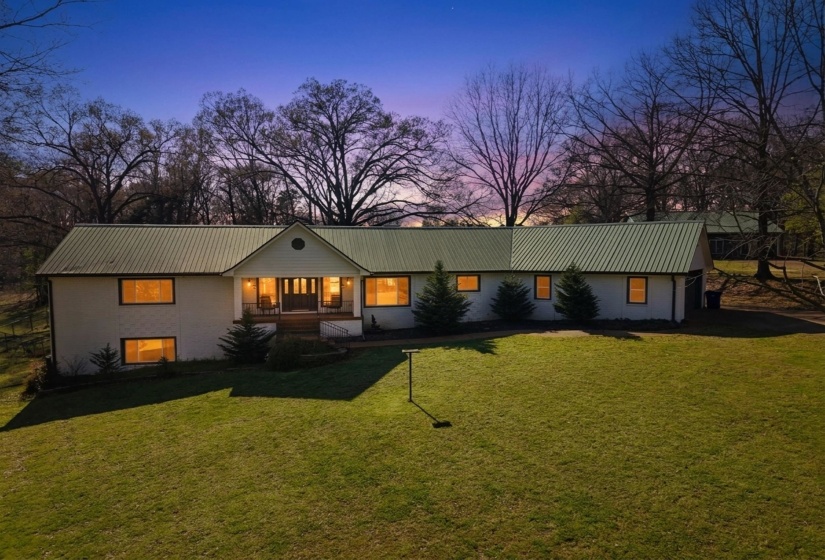 View of front of house featuring a front yard, a porch, and a metal roof