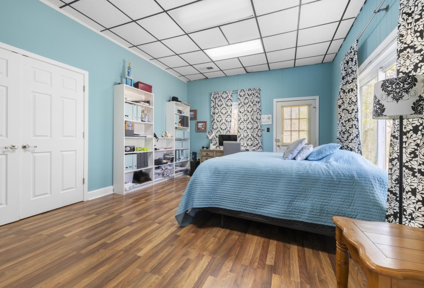 Bedroom featuring a drop ceiling and dark wood-style floors