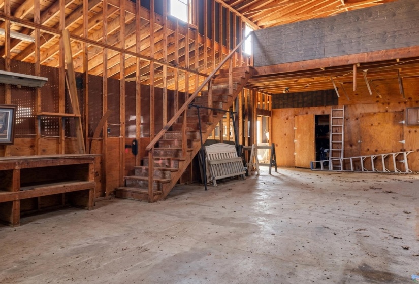 BARN featuring a high ceiling and unfinished concrete floors and loft
