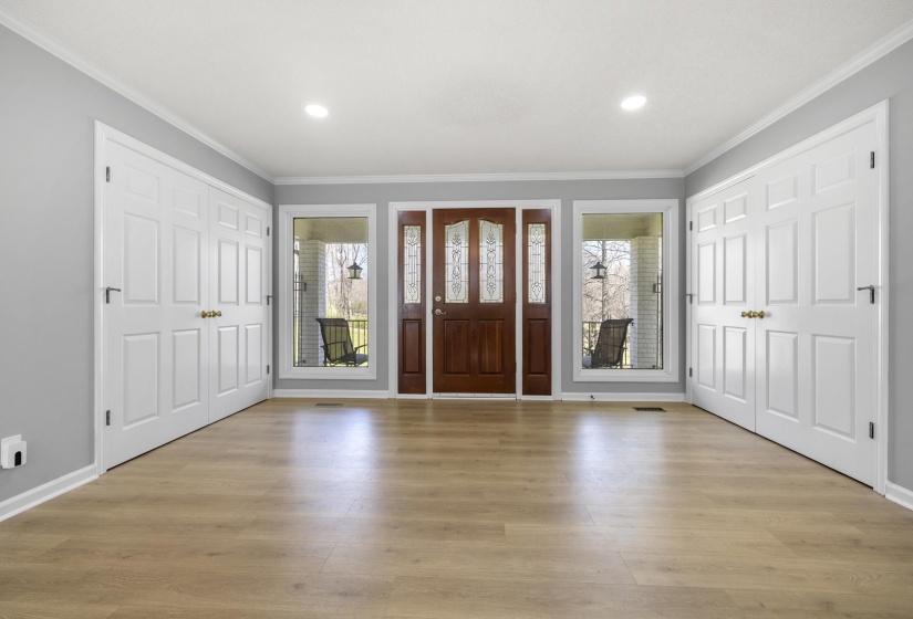 Entrance foyer with ornamental molding, light wood finished floors, and recessed lighting