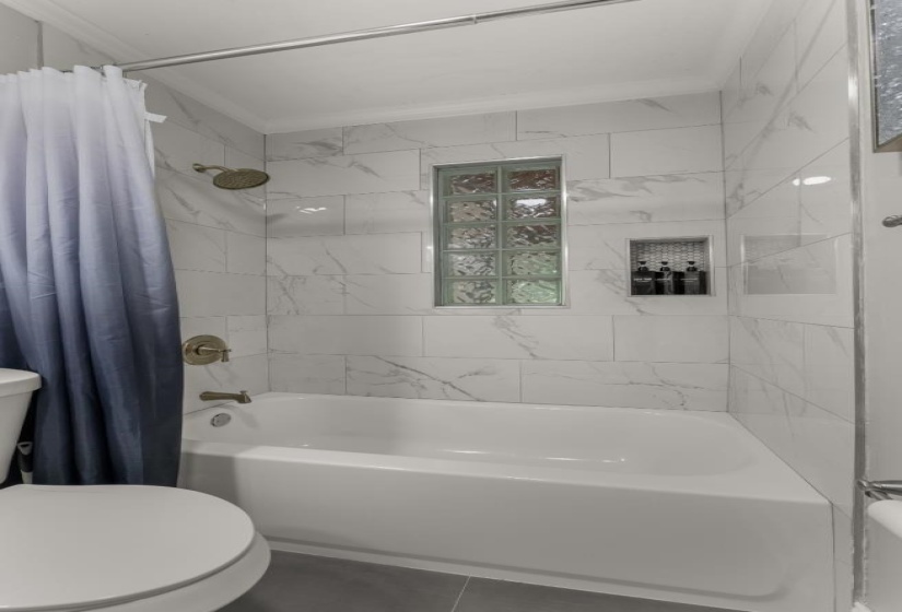 Full bathroom featuring shower / bath combination with curtain, ornamental molding, and tile patterned floors