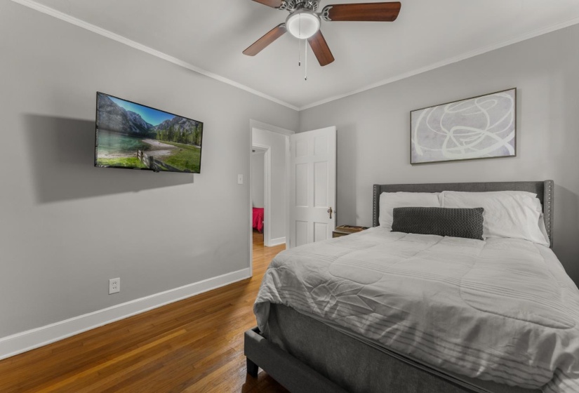 Bedroom featuring ornamental molding, hardwood / wood-style flooring, and ceiling fan