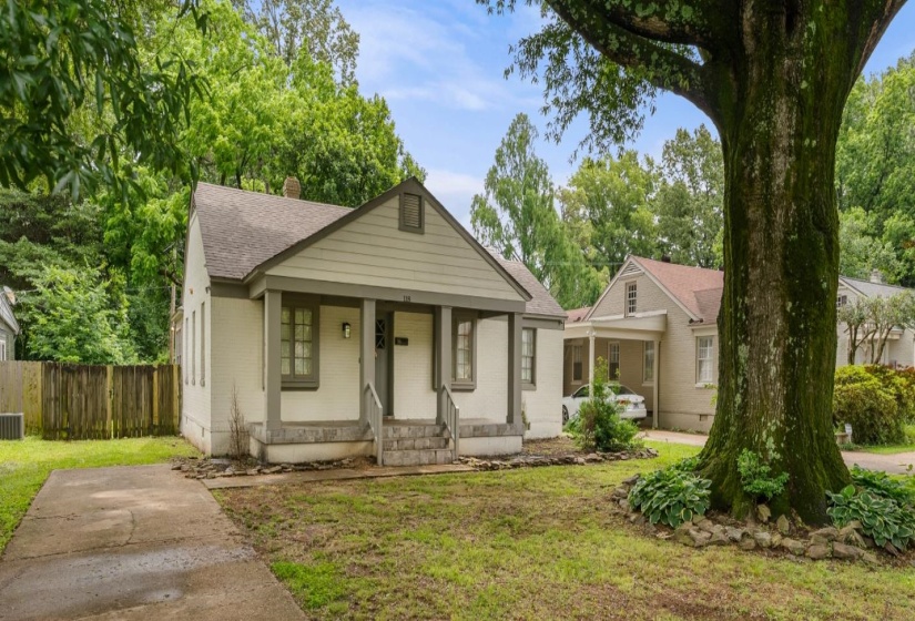 Bungalow with covered porch, a chimney, a shingled roof, and brick siding