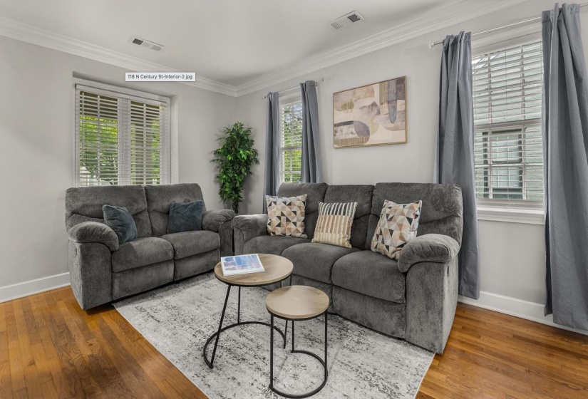 Living room with hardwood / wood-style floors and ornamental molding