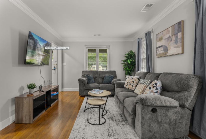 Living area featuring wood finished floors and ornamental molding