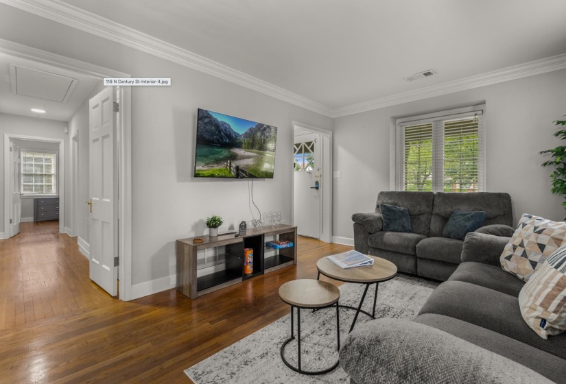 Living room with hardwood / wood-style flooring and ornamental molding