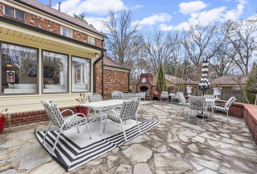 View of patio with outdoor dining space and an outdoor fireplace