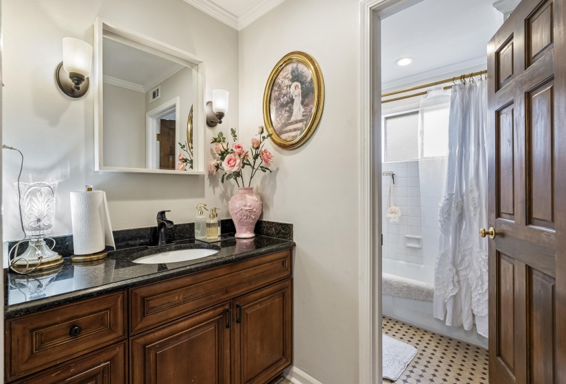 Bathroom featuring vanity, crown molding, shower / bathtub combination with curtain, and light flooring