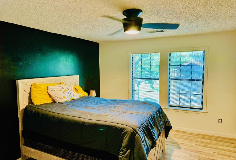 Bedroom with wood finished floors, ceiling fan, and a textured ceiling