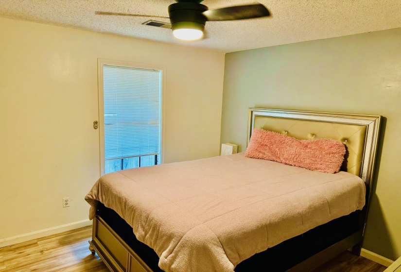 Bedroom with a textured ceiling, a ceiling fan, and light wood-style floors