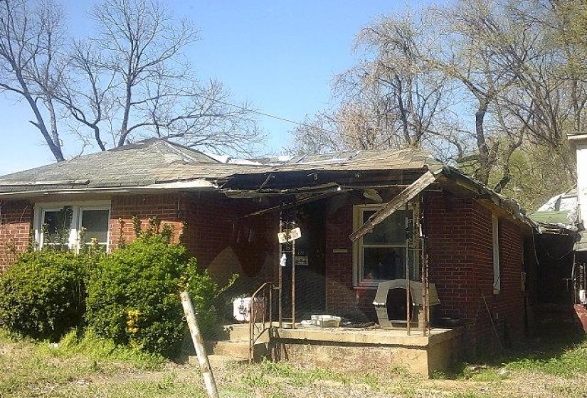 View of front of property featuring brick siding and covered porch