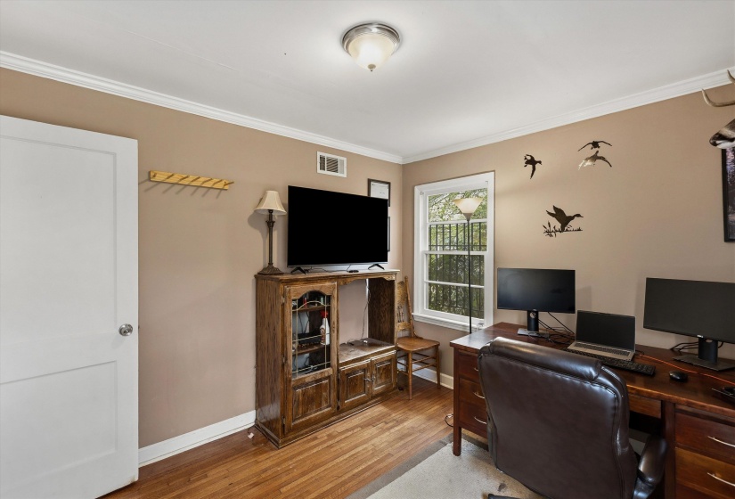 Office space with wood finished floors and crown molding