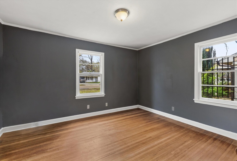 Empty room with light wood-style floors and crown molding