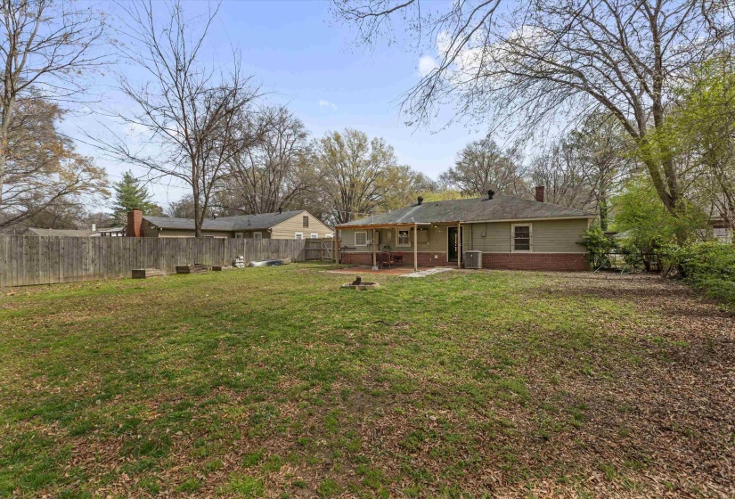 Rear view of property with a fenced backyard, a patio, and brick siding