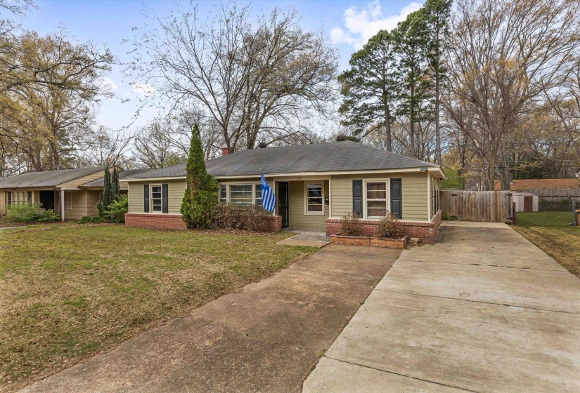 View of front of house with concrete driveway, a front yard, and brick siding