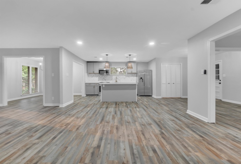 Kitchen with appliances with stainless steel finishes, open floor plan, gray cabinets, and recessed lighting