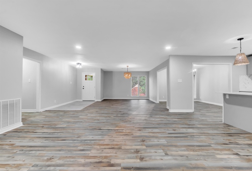 Unfurnished living room featuring wood finished floors, baseboards, and recessed lighting