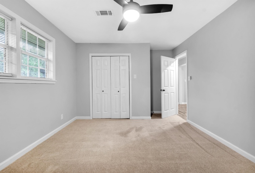 Unfurnished bedroom featuring baseboards, light colored carpet, a closet, and ceiling fan