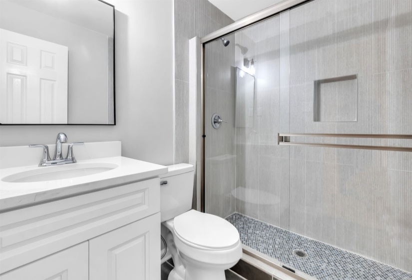 Full bathroom featuring toilet, a shower stall, and vanity