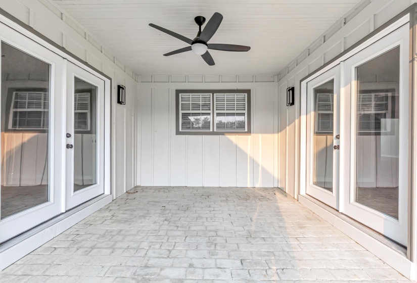 Unfurnished sunroom with french doors and brick floors