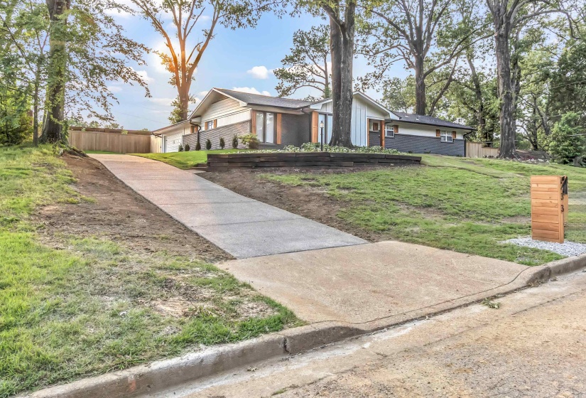 Mid-century inspired home featuring brick siding, concrete driveway, and a garage