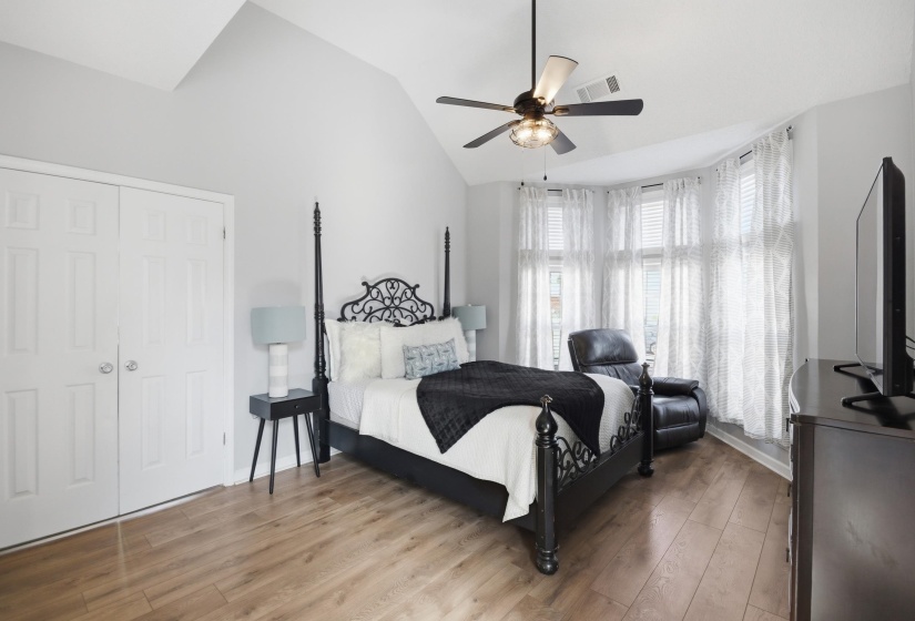 Bedroom featuring light wood finished floors, vaulted ceiling, and a ceiling fan