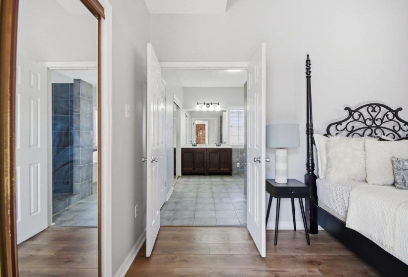 Bedroom with connected bathroom and dark wood-type flooring