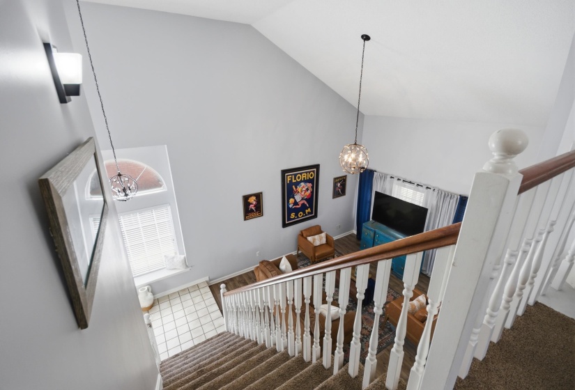 Staircase featuring a chandelier, carpet, and a high ceiling
