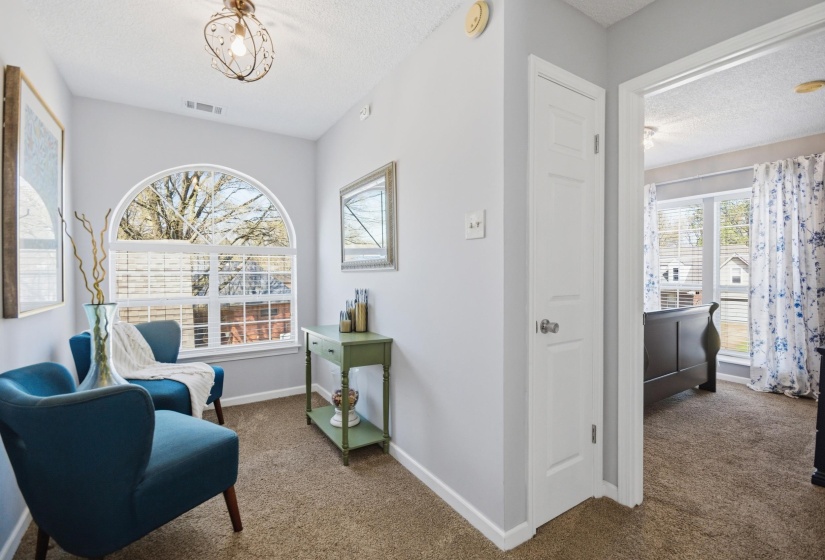 Sitting room with dark carpet and a textured ceiling