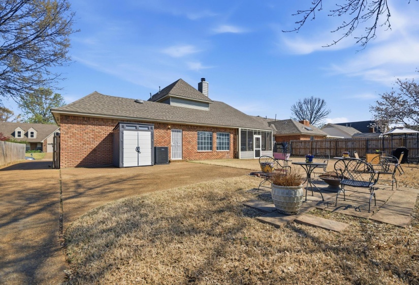 Rear view of house featuring a patio area, a fenced backyard, brick siding, a shingled roof, and a chimney