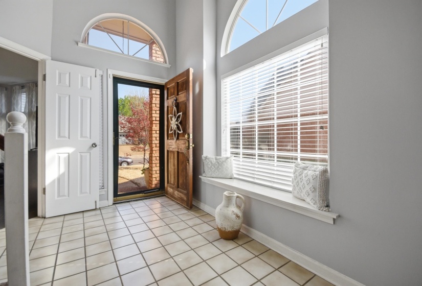 Entryway featuring light tile patterned floors, plenty of natural light, and a high ceiling