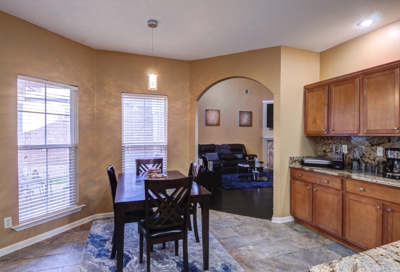Dining space featuring arched walkways and light stone finish floors