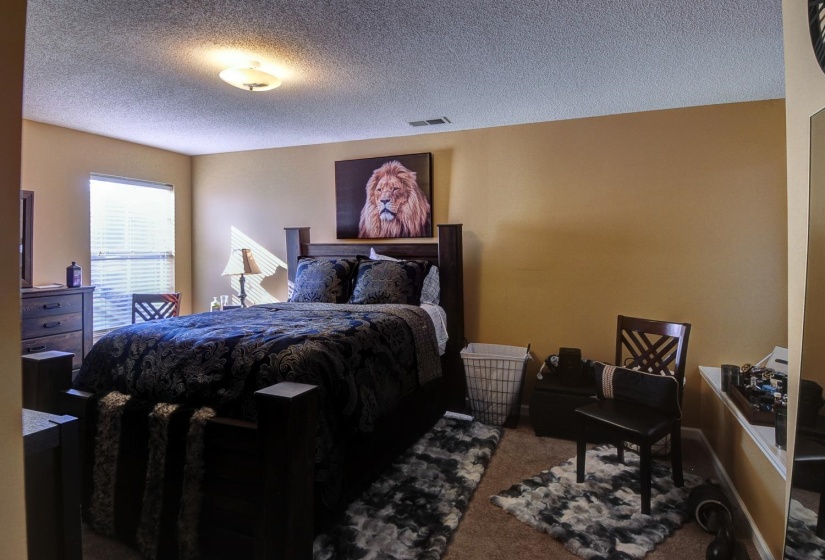 Bedroom featuring carpet floors and a textured ceiling