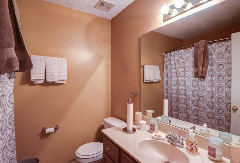 Bathroom with vanity, curtained shower, and a textured ceiling