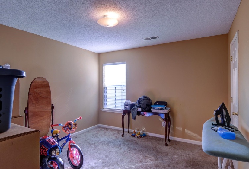 Workout area featuring a textured ceiling and light colored carpet