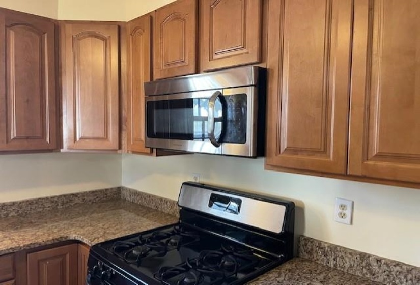 Kitchen with stone counters and black gas range oven
