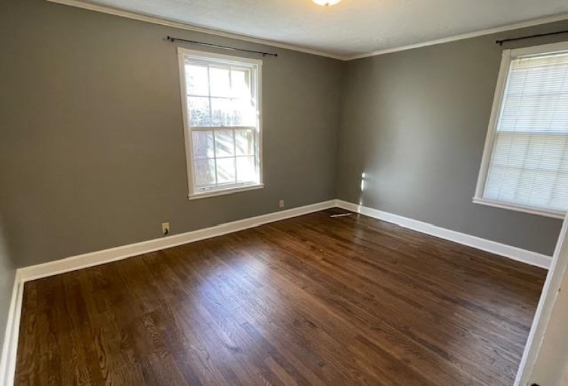 Unfurnished room featuring crown molding and dark hardwood / wood-style flooring