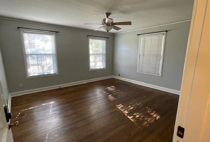 Spare room with ceiling fan, crown molding, and dark hardwood / wood-style floors