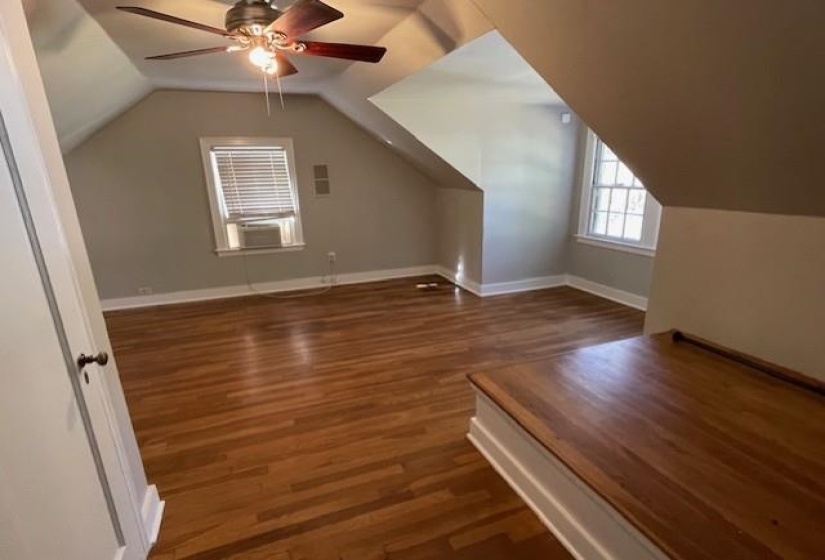 Bonus room with dark hardwood / wood-style flooring, ceiling fan, and lofted ceiling