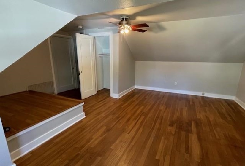Additional living space with ceiling fan, dark hardwood / wood-style flooring, and lofted ceiling