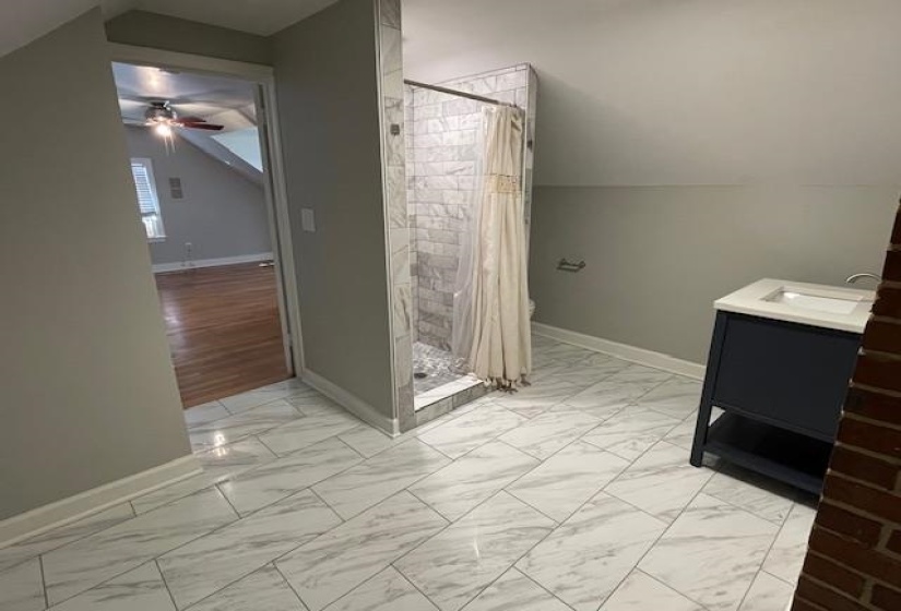 Bathroom with a shower with curtain, vanity, vaulted ceiling, and ceiling fan