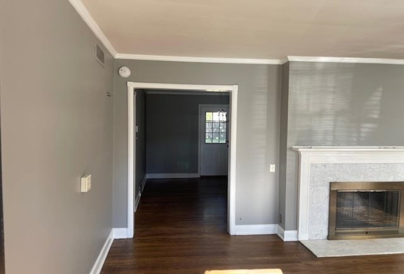 Unfurnished living room featuring dark hardwood / wood-style floors and ornamental molding