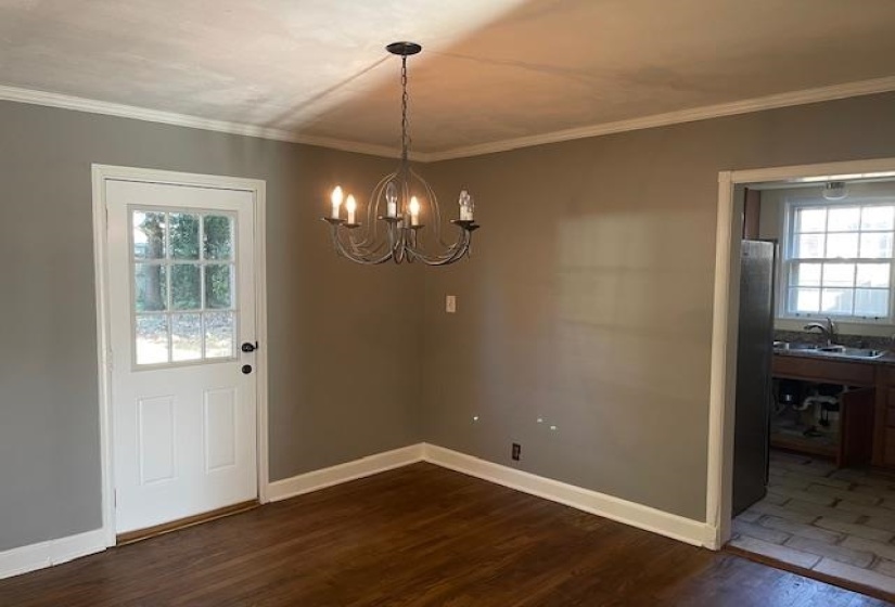 Unfurnished dining area featuring crown molding, dark hardwood / wood-style flooring, and sink