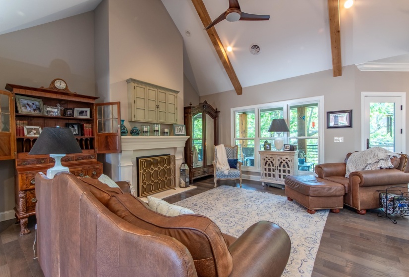 Living room featuring ceiling fan, dark hardwood / wood-style flooring, high vaulted ceiling, and beam ceiling